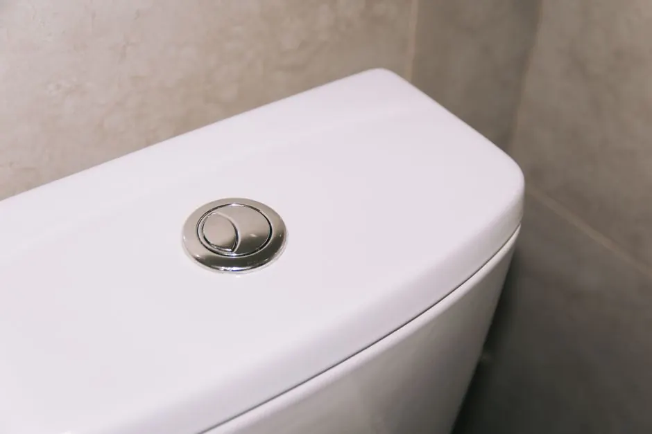 Close-up of a toilet tank and flush button