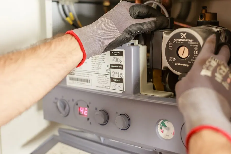 Plumber repairing the controls on a water heater